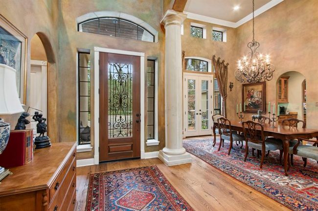 The open and airy foyer showcases several consistent architectural features found throughout such as arched doorways, niches, transom windows and reclaimed wood floors with an oiled finish. | Image 5