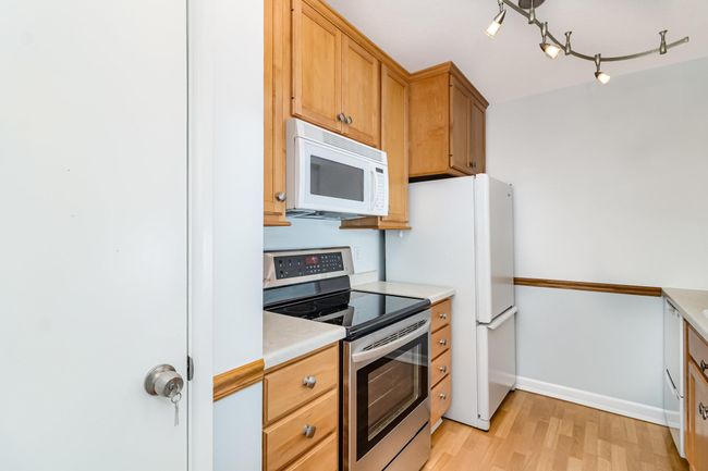 Kitchen has lovely cabinetry and hardware with extra storage provided by a pantry and nearby entry closet | Image 7