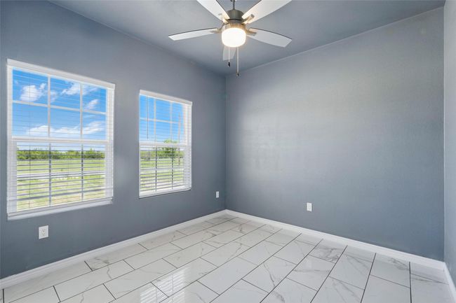 Unfurnished room with tile finish floor, baseboards, and a ceiling fan | Image 17