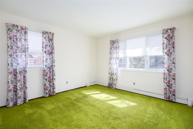 Carpeted empty room featuring a baseboard radiator and plenty of natural light | Image 28