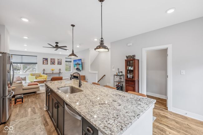 kitchen featuring open floor plan, light wood-style flooring, a sink, and appliances with stainless steel finishes | Image 7