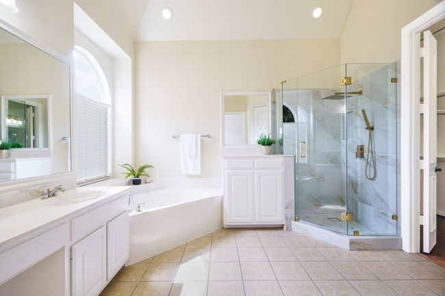 Full bath featuring tile flooring, double vanities, jetted tub and a beautiful shower | Image 12