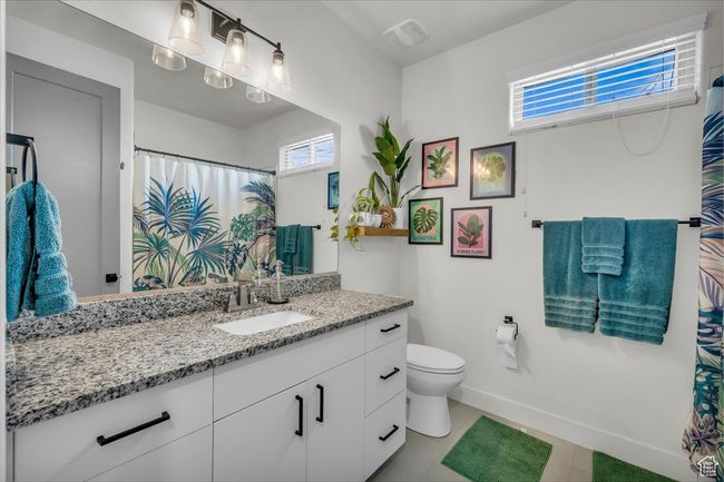 Bathroom with baseboards, visible vents, toilet, and vanity | Image 17