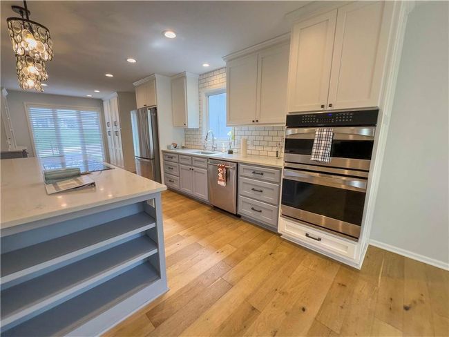 Kitchen with tasteful backsplash, recessed lighting, appliances with stainless steel finishes, a sink, and light countertops | Image 8
