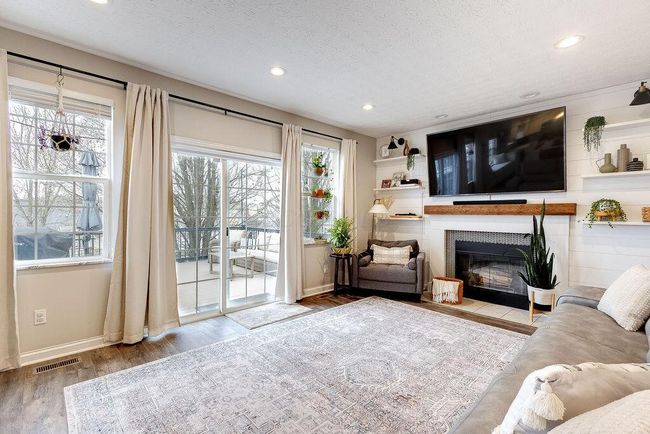Family room with fireplace and tastefully updated shiplap wall and fireplace surround. | Image 10