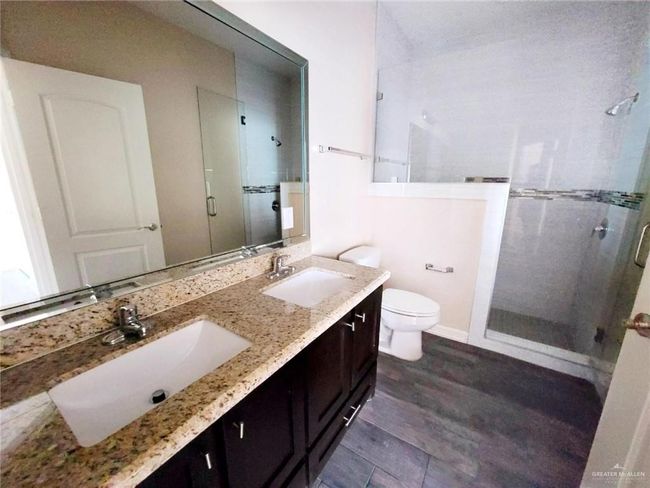 Full bathroom with a stall shower, double vanity, and wood finished floors | Image 18