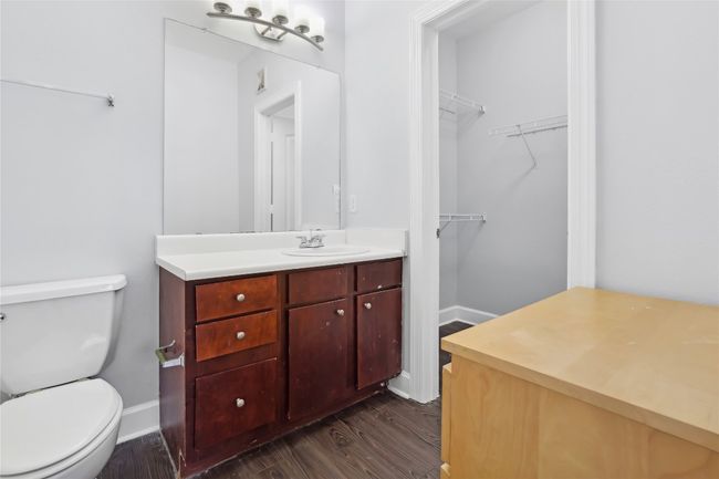 Bathroom featuring toilet, a spacious closet, wood finished floors, and vanity | Image 19