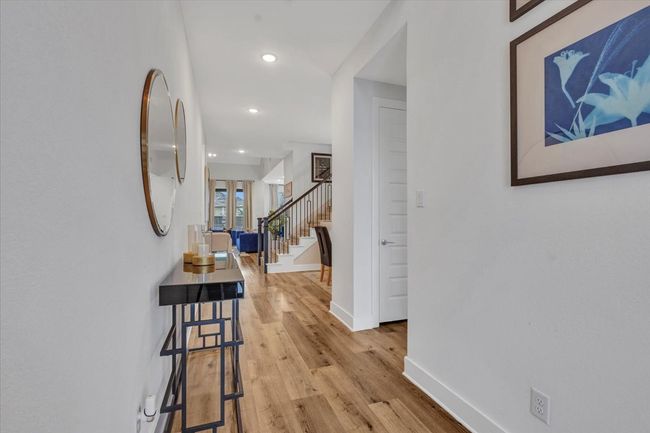 This warm entry way gives you a peek of what is in store: tall baseboards, wood flooring throughout the first floor, and recessed lighting that showcase a beautiful staircase. | Image 5