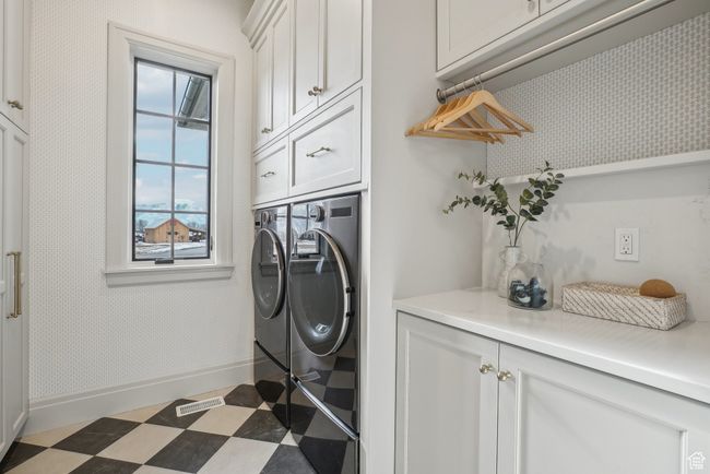 Laundry area featuring dark floors, visible vents, baseboards, washer and dryer, and cabinet space | Image 22