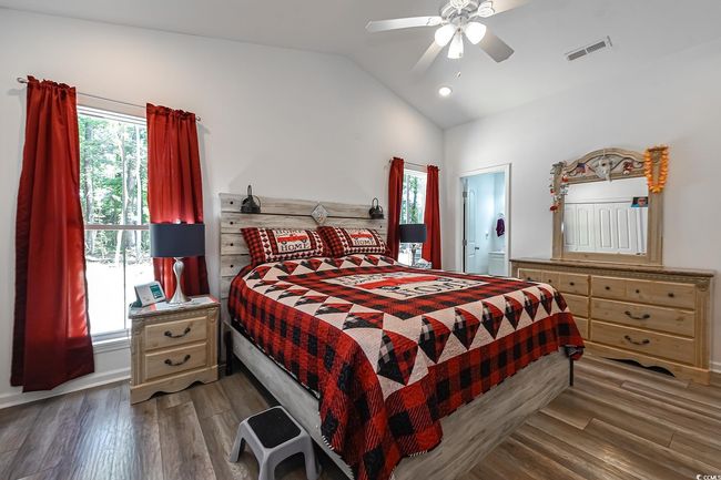 Bedroom featuring lofted ceiling, wood finished floors, a ceiling fan, and baseboards | Image 17