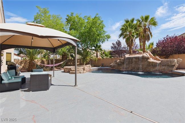 View of patio featuring an outdoor living space, a fenced backyard, a fenced in pool, and a gazebo | Image 44