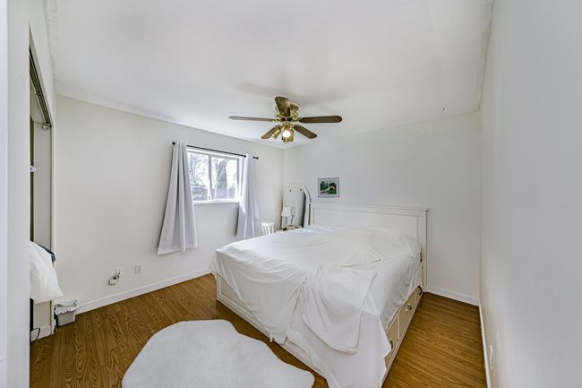 Bedroom with baseboards, wood finished floors, and a ceiling fan | Image 10