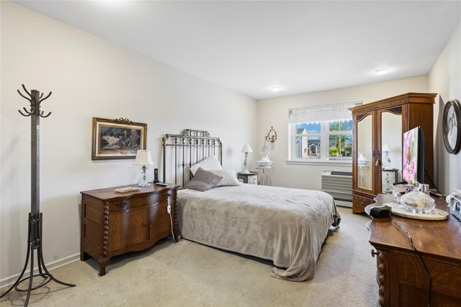 Bedroom with light carpet, an AC wall unit, and baseboards | Image 21