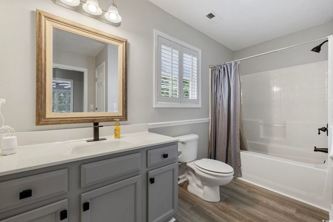 Full bathroom with vanity, shower / tub combo with curtain, toilet, and wood finished floors | Image 15