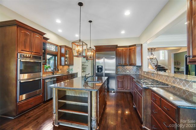 Gourmet kitchen with ss appliances, gas cook top, center island, granite counters, and tons of storage space | Image 10