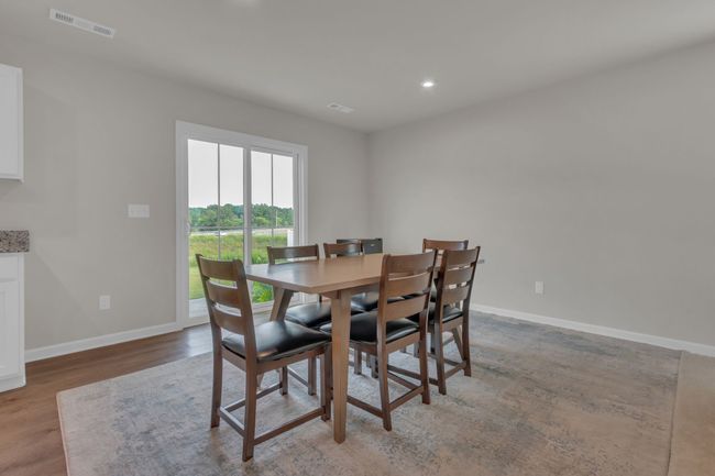 Dining room bathed in natural light, featuring a sliding glass door that opens seamlessly to the patio. | Image 14