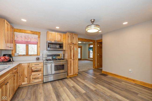 kitchen with light countertops, backsplash, light wood-style floors, and appliances with stainless steel finishes | Image 5