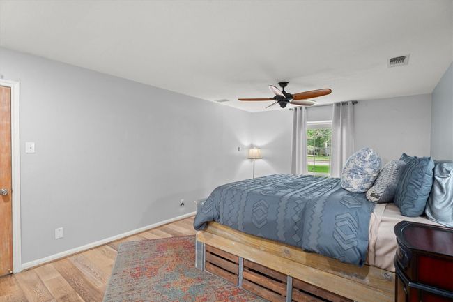 This primary bedroom features ample space with natural lighting, creating a calm and inviting atmosphere. | Image 24