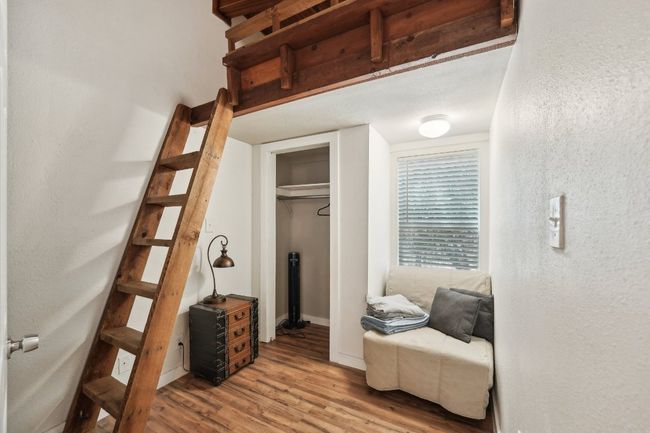 Bedroom with wood finished floors, baseboards, a textured wall, and a closet | Image 17