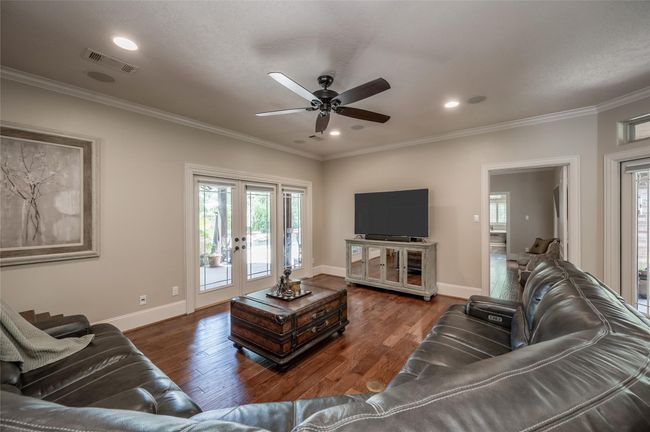 Experience abundant natural light in the open living area, enhanced by two sets of French doors leading to separate covered porches. | Image 8
