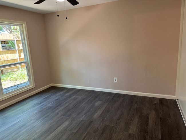 Spare room featuring dark wood-style flooring and ceiling fan | Image 6