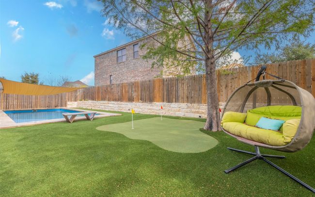 Rear view of property featuring a fenced in pool, a lawn, and a sunroom | Image 29
