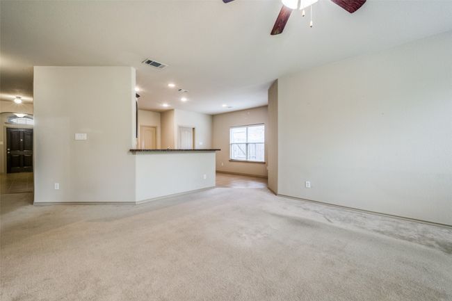 Unfurnished living room featuring light carpet and ceiling fan | Image 4