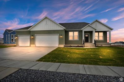 View of front of property featuring a yard and a 3 car garage | Image 1