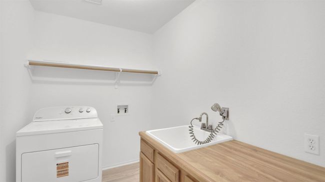 Laundry room featuring washer / clothes dryer, cabinet space, and light vinyl plank flooring | Image 25