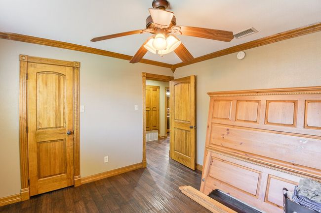 Bedroom featuring ornamental molding, dark wood finished floors, and a ceiling fan | Image 19