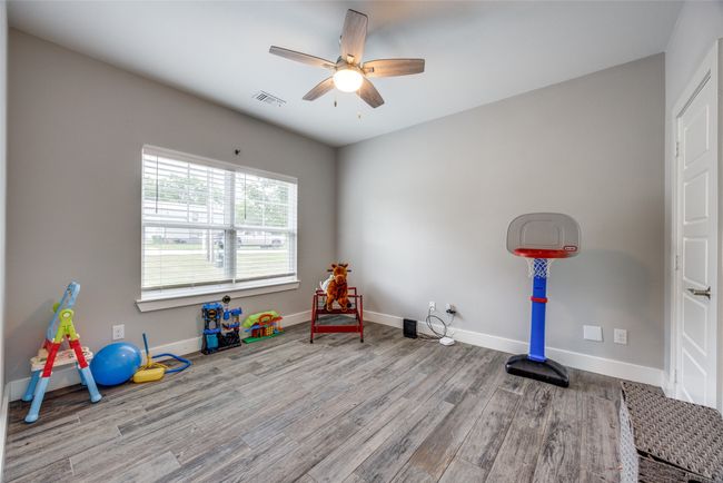 Recreation room featuring wood finished floors, a ceiling fan, and baseboards | Image 7