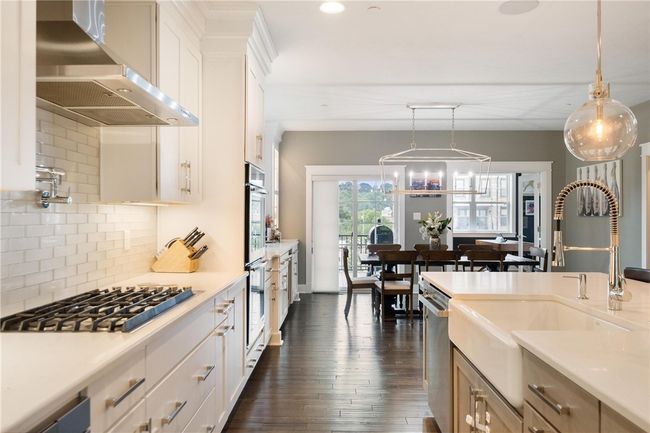 Kitchen opens to Dining area and hardwood continues into Dining area. | Image 11