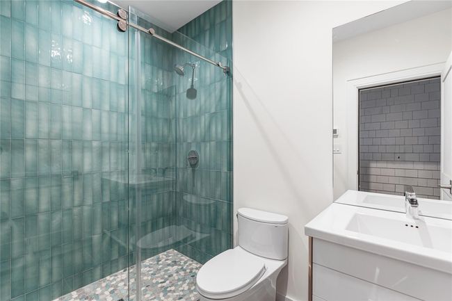 Bathroom featuring a shower stall, toilet, and vanity | Image 37