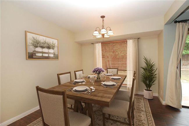 Dining area featuring a chandelier and wood-like tile floors | Image 9