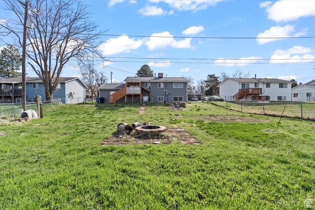 View of yard with a fenced backyard, a fire pit, stairway, and a residential view | Image 22