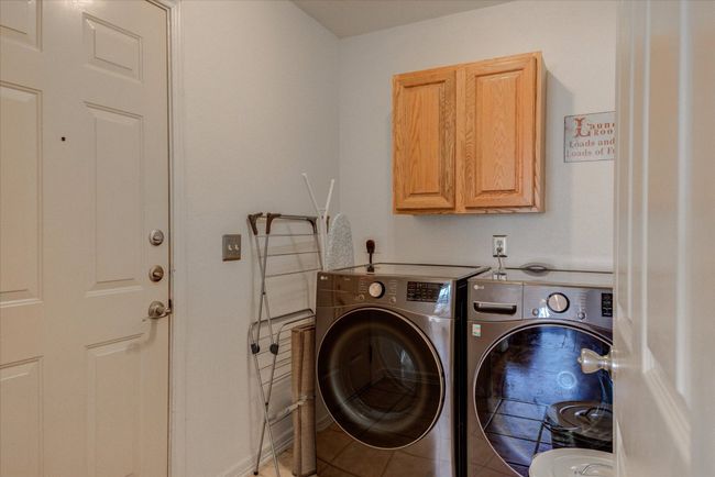 The laundry features tile floors, and new washer and dryer. Exit to garage from laundry. | Image 13