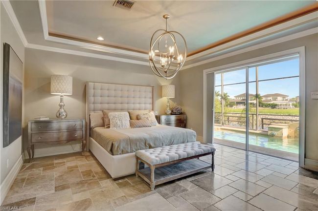 Bedroom with an inviting chandelier, visible vents, a tray ceiling, and access to outside | Image 27