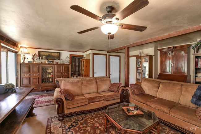 Living area with a ceiling fan and concrete flooring | Image 40