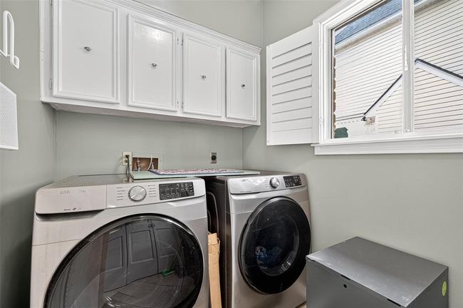 More than utilitarian, this laundry space features built-in cabinetry, a large window, and room to move—proof that even the functional spaces have been thoughtfully designed. | Image 26