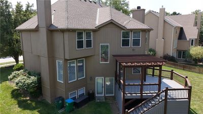 View of front of house with a wooden deck, a front lawn, and a pergola | Image 2