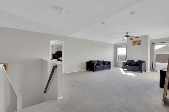 Living area featuring baseboards, light colored carpet, visible vents, and an upstairs landing | Image 25