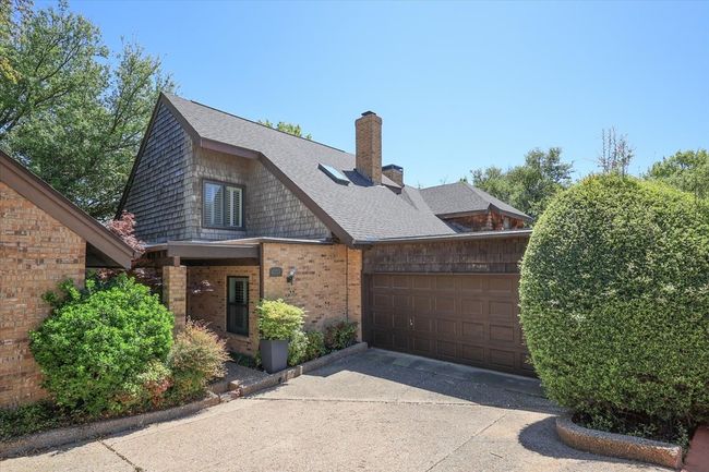 View of front of home featuring roof with shingles, brick siding, a chimney, a garage, and concrete driveway | Image 11