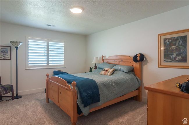 Bedroom featuring carpet, a textured ceiling, and baseboards | Image 22