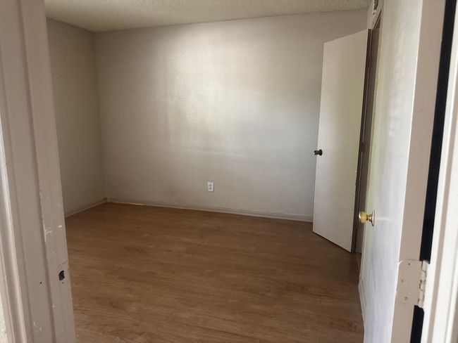 Empty room featuring wood finished floors and a textured ceiling | Image 7