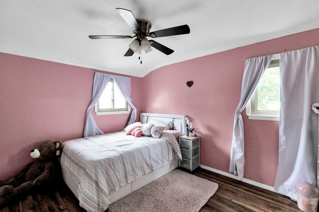 Bedroom featuring wood finished floors, ornamental molding, ceiling fan, and baseboards | Image 9