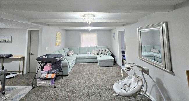 Living area with beam ceiling and carpet flooring | Image 14
