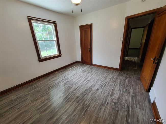 Empty room featuring dark wood-style flooring and ceiling fan | Image 9