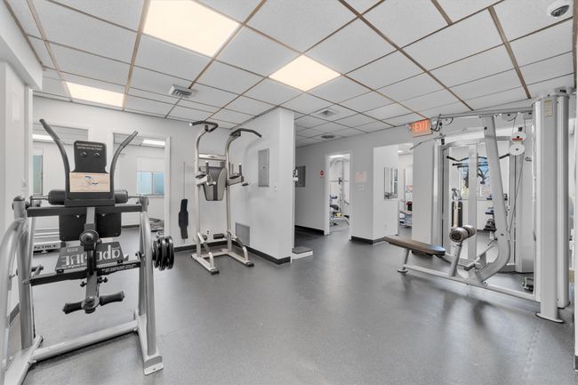 Exercise room featuring visible vents, electric panel, baseboards, and a drop ceiling | Image 27