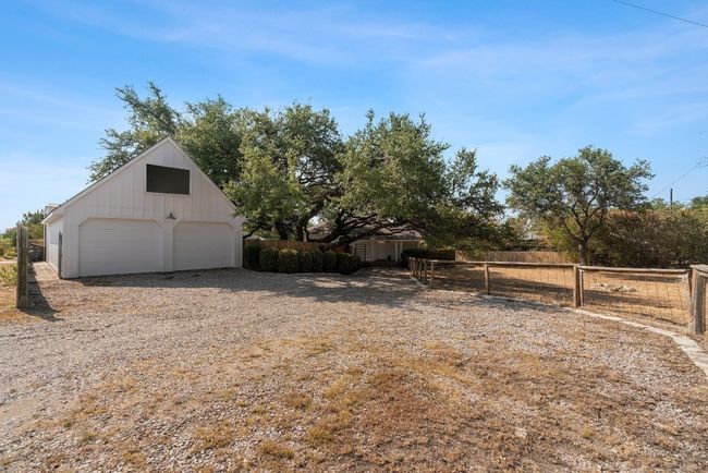 View of yard featuring a garage, an outbuilding, and fence | Image 24