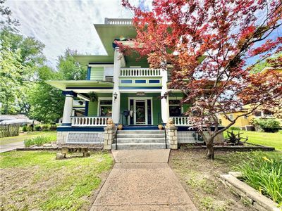 View of front of property featuring a front yard, a balcony, and covered porch | Image 1